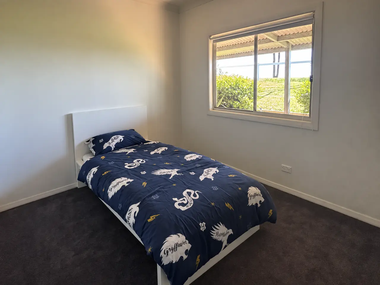 Bedroom with a single bed and a window looking out over the paddock